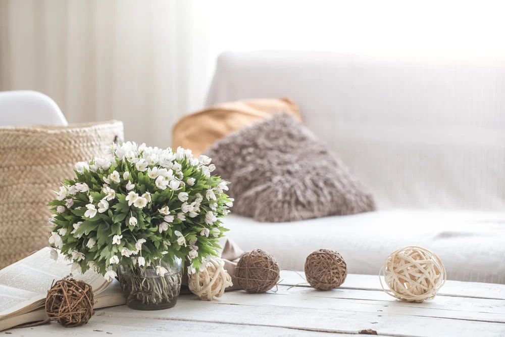 Cozy living room with flowers and decorative pillows.