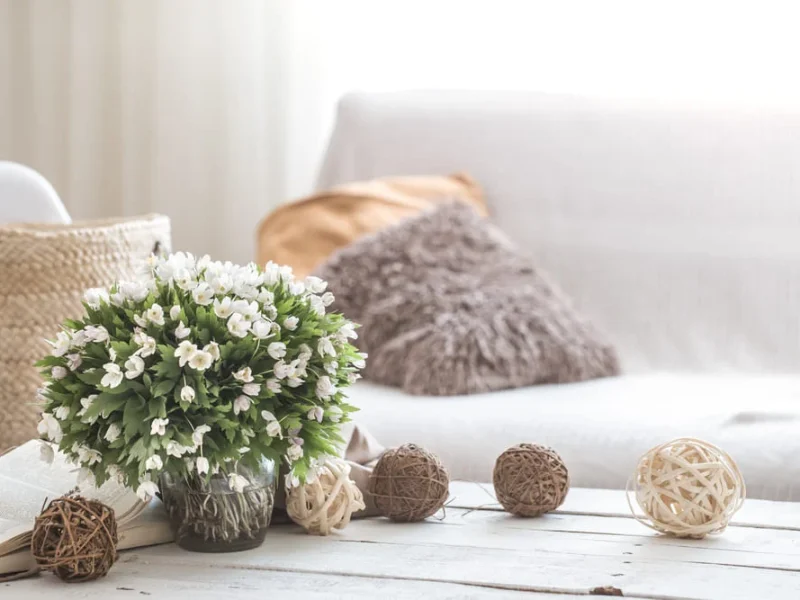 Cozy living room with flowers and decorative pillows.